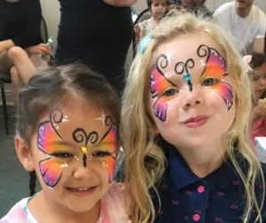 Two children with colourful butterfly face paint